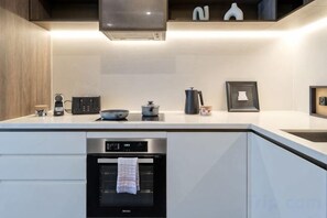 Une cuisine moderne dotée d’appareils électroménagers intégrés, d’un four à micro-ondes et d’une machine à café.