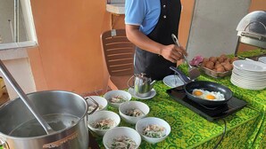 A table with various food items and a person cooking.