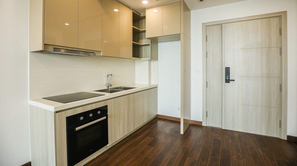 A modern kitchen with wooden cabinets, a built-in oven, and a sink.