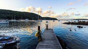 Une jetée en bois s’étendant sur des eaux calmes, avec des bateaux amarrés à proximité.