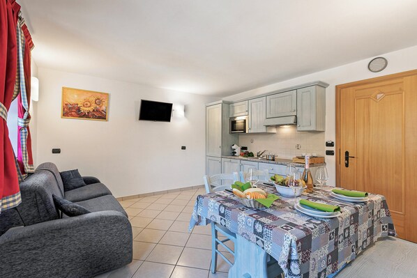 A compact living space with a dining area, kitchen, and a grey sofa. - Archillea, Livigno, Italy (Livigno)
