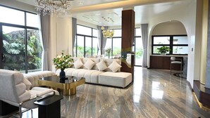 Ein geräumiges Wohnzimmer mit einer großen Couch, einem Couchtisch und einer Chandelier.