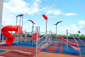 Ein Spielplatz mit Rutschen und Klettergerüsten.