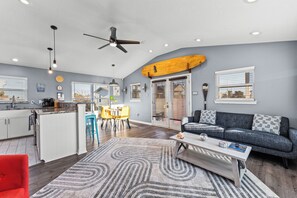A modern living room with a gray sofa, a coffee table, and a red chair. - HOT TUB • LUXURY GOLF CART! • OUTDOOR BAR & TV • 5 MIN TO THE BEACH • PETS (Jamaica Beach)