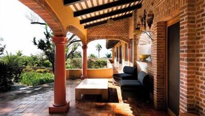 A covered outdoor seating area with brick walls, arches, and a tiled floor. - ANANA Rancho San Rafael Pool and Lake Views (Ajijic)