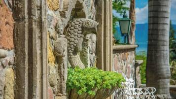 A stone wall with a fish carving and a planter with green plants.
