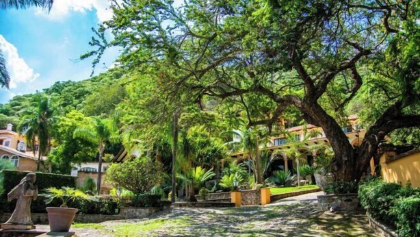 A courtyard with a cobblestone path, large trees, and a statue. - ANANA Rancho San Rafael Pool and Lake Views (Ajijic)