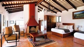 A room with a fireplace, a bed, a sofa, and a dining table. - ANANA Rancho San Rafael Pool and Lake Views (Ajijic)