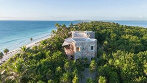 A beachfront property with a house surrounded by dense palm trees and a view of the ocean. - ANANA Casa Kaab Kaan Rooftop pool & Beachfront (Tulum)