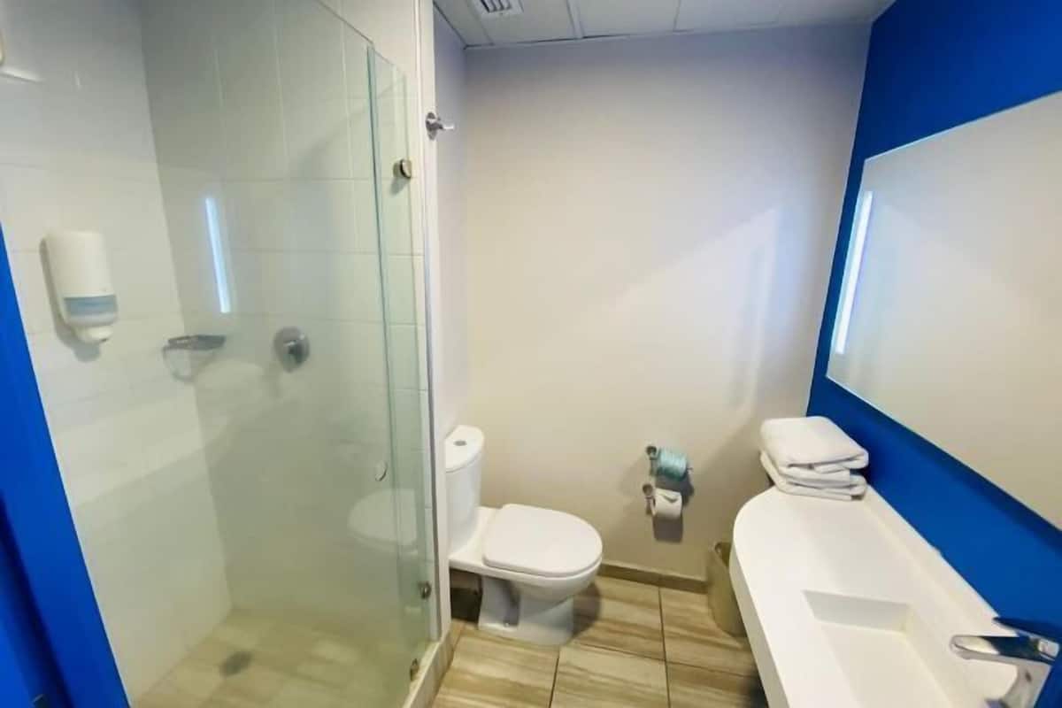 A bathroom with a glass-enclosed shower, a toilet, and a bathtub.