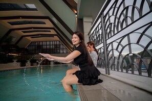 Zona de piscina con diseño arquitectónico moderno, que incluye una barandilla geométrica y un techo alto con tragaluces.