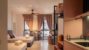 A modern hotel room with two beds, a dining area, a kitchenette, and a large window with curtains. - Paxtonz KL Walk to Mall & Pool (Petaling Jaya)