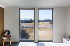 Une chambre dotée d’une grande porte-fenêtre coulissante donnant sur un terrain de golf.