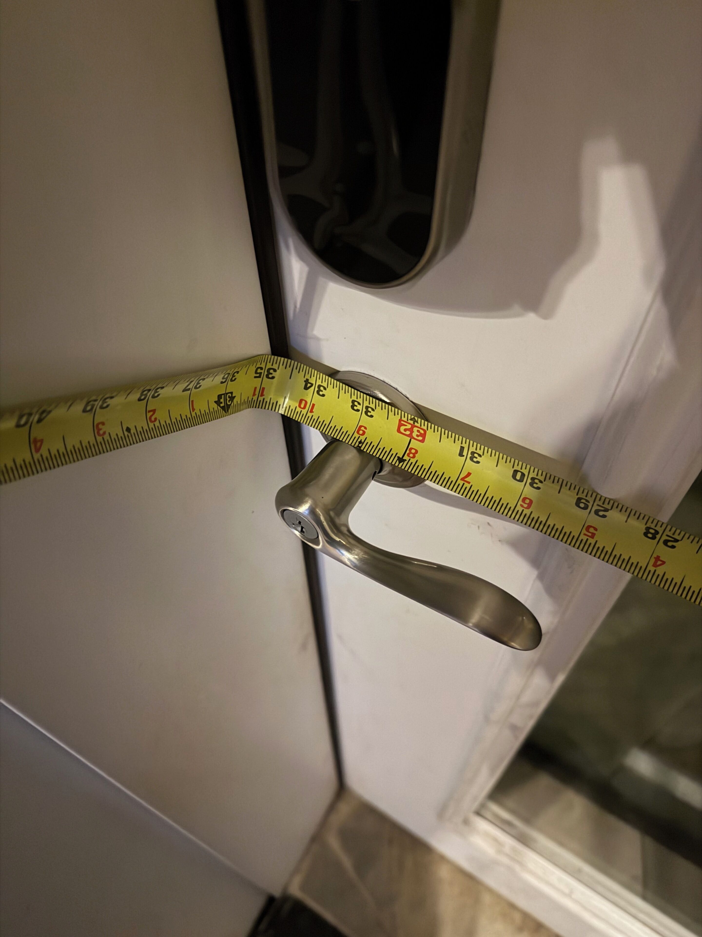 Mittanauha on kiertetty oven kahvan ympärille, ja se osoittaa oven leveyden.