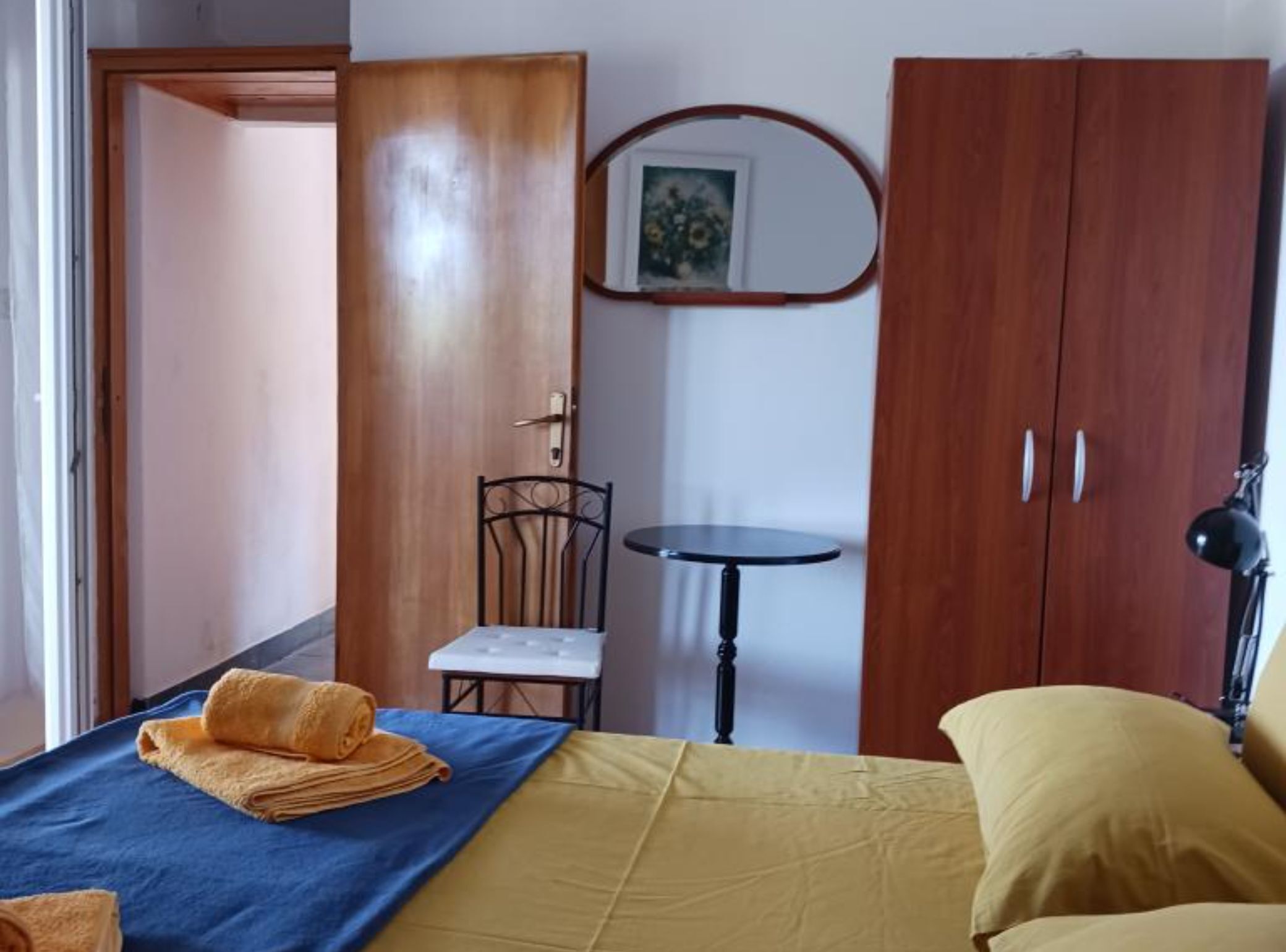 Ein Schlafzimmer mit einem Bett, einem Sessel, einem kleinen Tisch und einem Kleiderschrank.