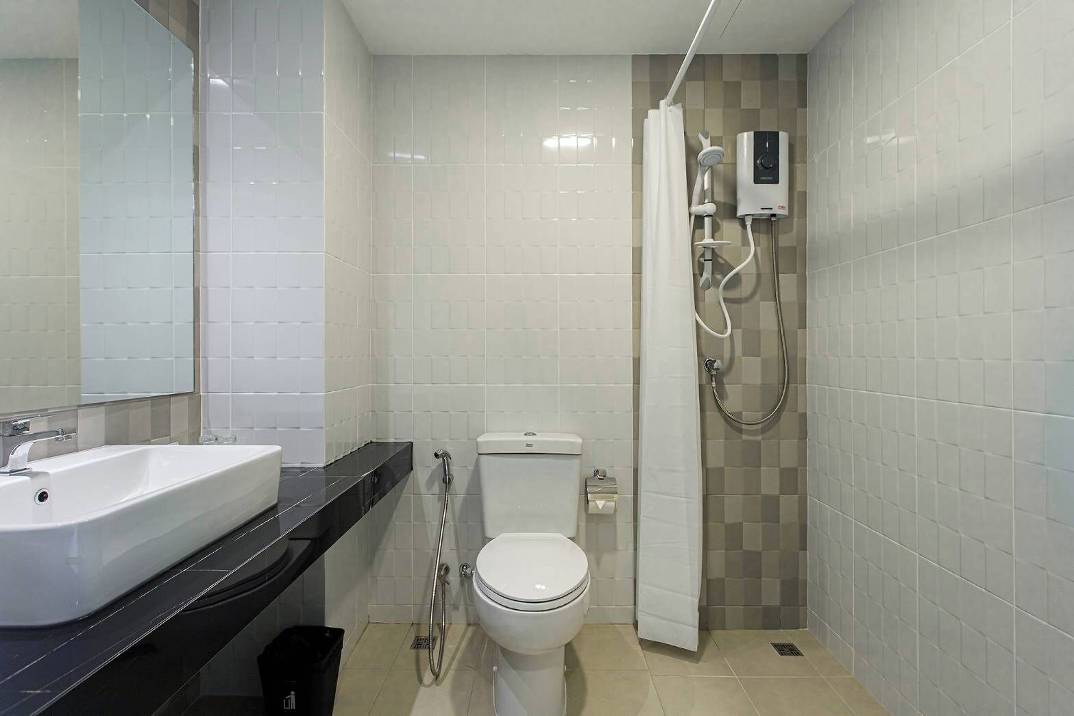 Ein kleines Badezimmer mit weißem Waschbecken, WC und Dusche.