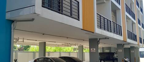 A multi-story parking garage with several cars and scooters parked.
