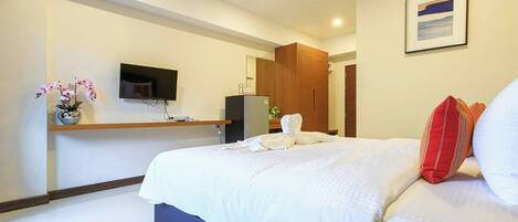 Una habitación de hotel con cama, televisión, escritorio y armario.