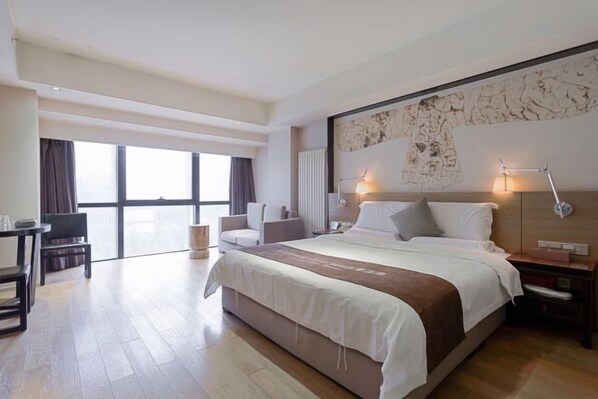 A modern hotel room with a large bed, a desk, and a chair. - Jumu·Yueting Hotel (Xi'an)