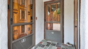 A wooden double door with a glass panel, numbered S8 and S2, leading to a tiled entrance.