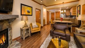 A cozy living room with a fireplace, comfortable seating, and a dining area.