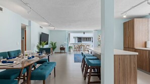 En moderne stue med spiseplads, et køkken og en balkon.