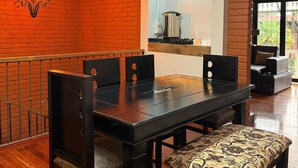 Un coin repas avec un mur en briques, un lustre, une machine à café et un canapé.