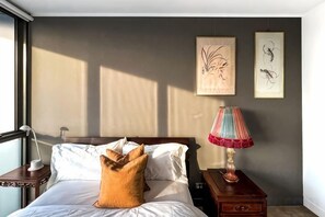 A hotel room with a bed, a nightstand, a lamp, and two wall art pieces. - Lux Docklands District 3-level TH FreeParking (Docklands)