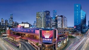 A cityscape with a prominent building featuring a 'Crown' sign, surrounded by high-rise buildings and busy streets. - Luxury Melbourne CBD Apt in Iconic QT Hotel (Melbourne)