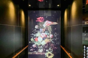 An elevator interior with a digital display of a floral arrangement. - Luxury Melbourne CBD Apt in Iconic QT Hotel (Melbourne)