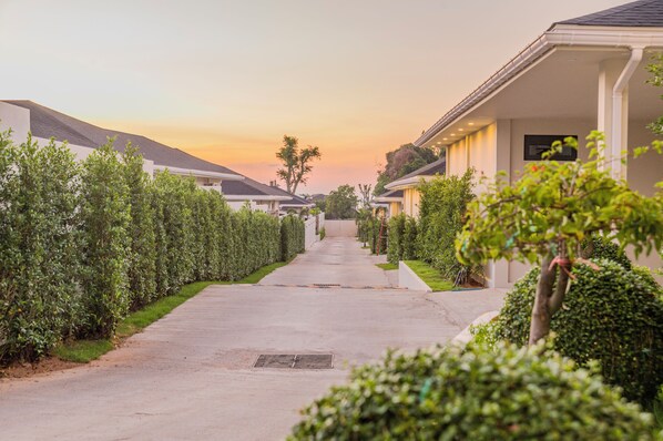 A residential street lined with houses, a clear sky, and a sunset. - Valentine Village (Koh Samui)