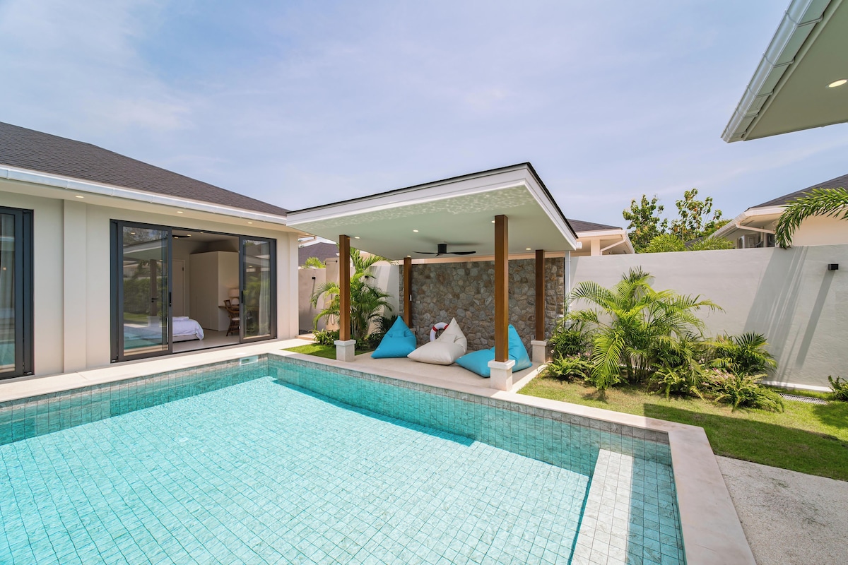 A modern house with a swimming pool, a covered patio, and a garden.