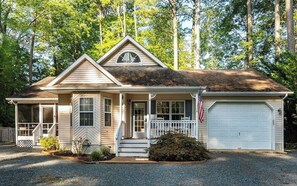 A single-story house with a front porch, a garage, and a small front yard. - Charming 4-bedroom Beach House in Ocean Pines (Ocean Pines)