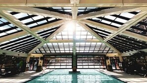 Ein Hallenbad mit hoher Decke und Dachfenstern.