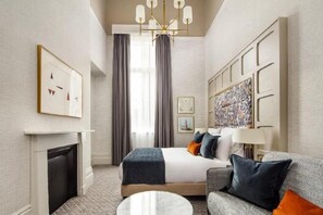 A hotel room with a bed, a sofa, a fireplace, and a chandelier. - The Municipal Hotel & Spa Liverpool - MGallery Collection (Liverpool)