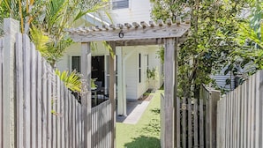 A wooden gate leading to a covered patio area with a number '6' sign. - Dianella Dunes (Casuarina)