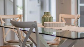 A dining table with chairs, a vase, and a plate. - Dianella Dunes (Casuarina)