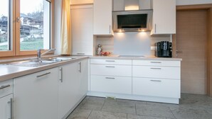Eine moderne Küche mit weißen Schränken, einer Edelstahl-Spüle und einem Einbauofen.