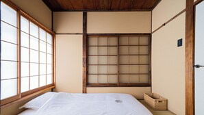 A traditional Japanese room with tatami flooring, a low wooden bed, shoji screens, and a woven basket. - Haku Yuukyu-no-Ten Japanese Style Residence/ Rarely available due to Tokyo's cold winters/ Rarely available due to Tokyo's cold winters/ In the heart of Shinjuku/ 4 minute walk from East Shinjuku Station/ Max 7 people/ Newly renovated/ Family friendly (Shinjuku City)
