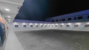 Amplio espacio interior con suelo de baldosas, varias puertas y techo azul.