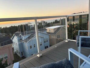 Un balcon offrant une vue dégagée sur les maisons voisines et sur le coucher de soleil.