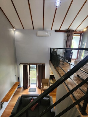 A modern interior with a wooden ceiling, a staircase, and a view of the outdoors. - Nana's Villa Sanur (Denpasar)