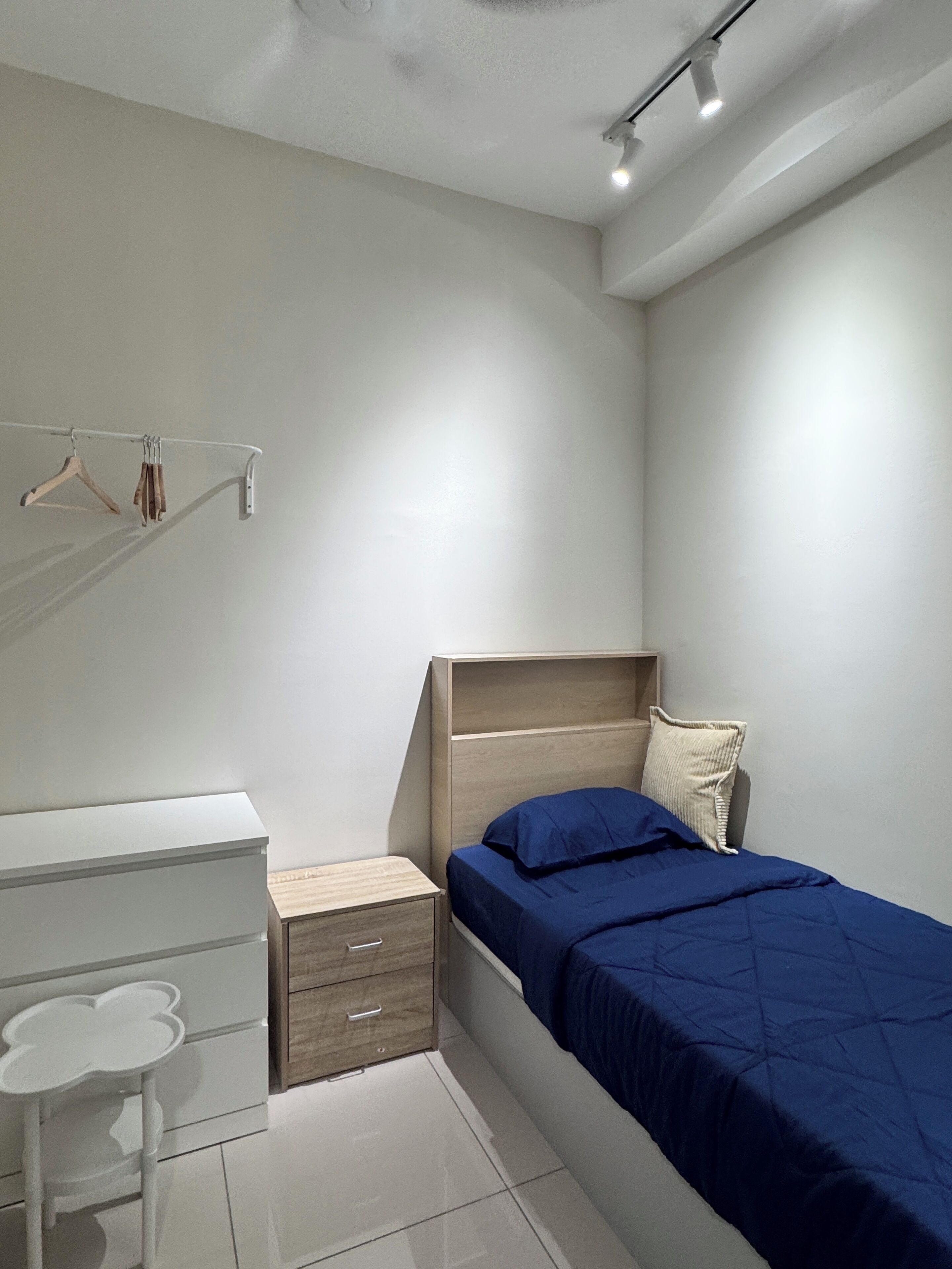 Un dormitorio con cama, escritorio y silla.