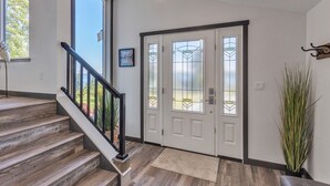 Eine Treppe führt zu einer Tür mit satinierten Glasscheiben, darüber hängt eine Leuchte und rechts steht ein Blumentopf.