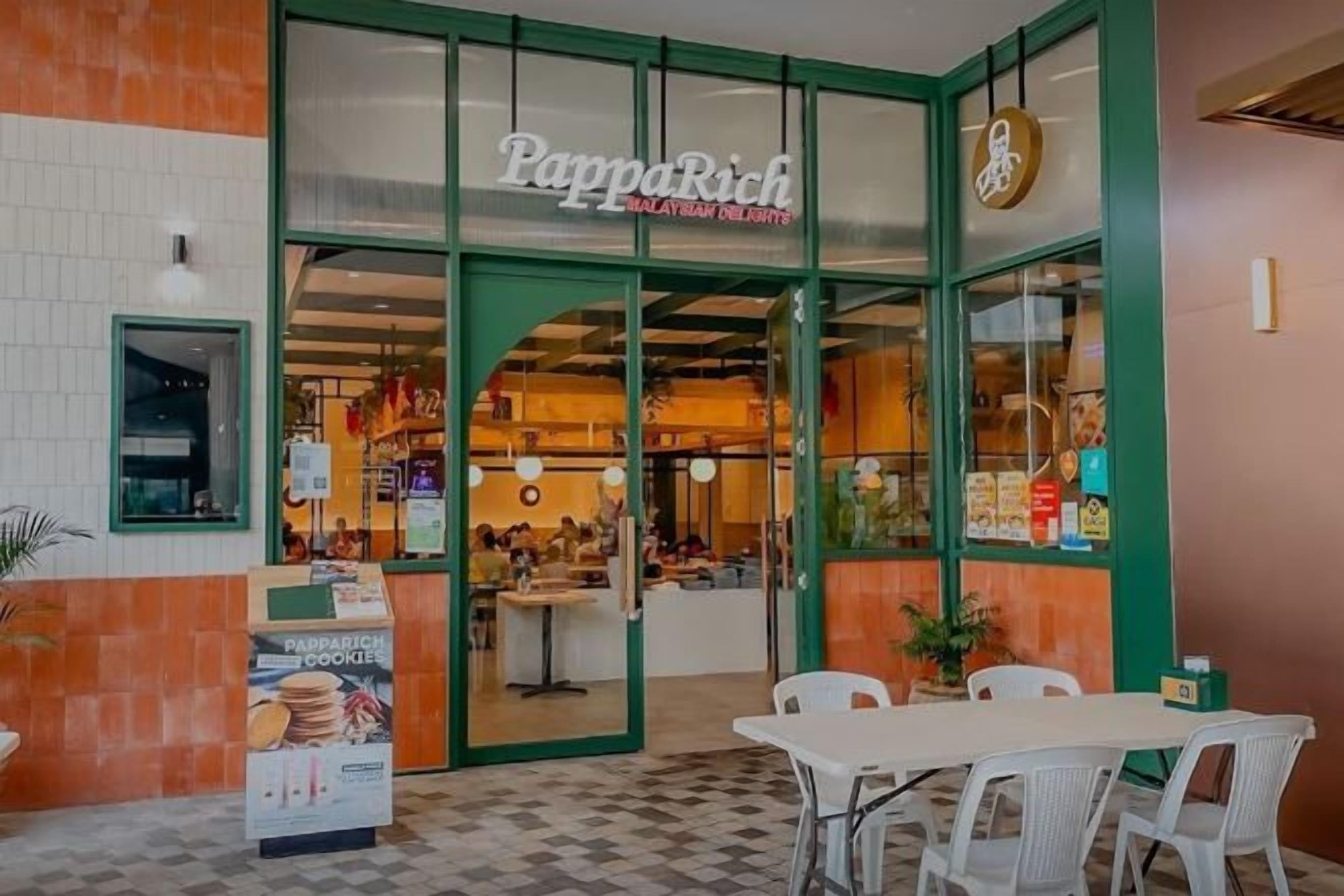 A restaurant named PappaRich with a green exterior and a checkered floor pattern.