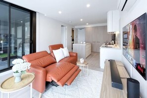 Un salon moderne avec un canapé, une table basse et un téléviseur.