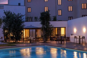 Una piscina al aire libre de temporada, sombrillas
