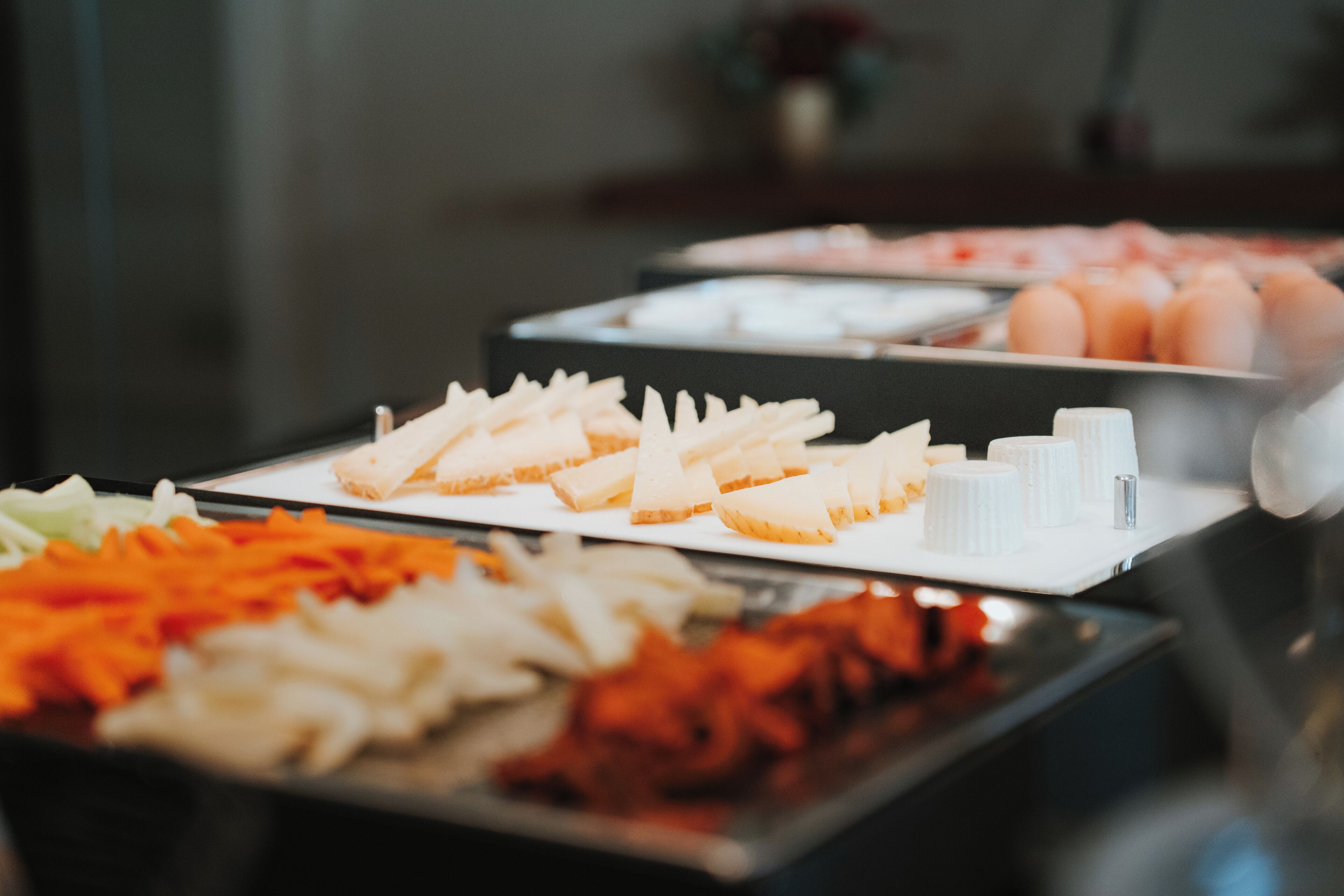 Un buffet proposant une variété d'aliments, notamment des viandes en tranches, des légumes et du pain.