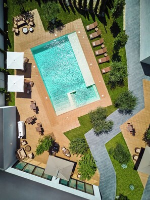 Una piscina al aire libre de temporada, sombrillas