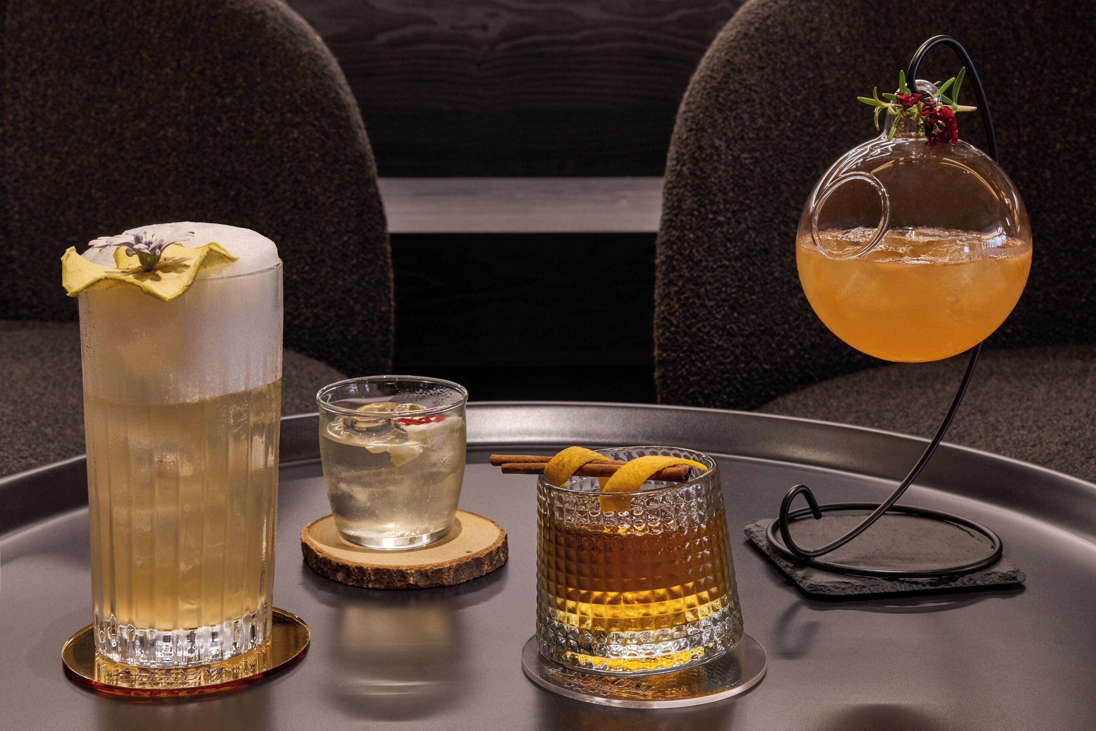 Three glasses of beverages on a tray.